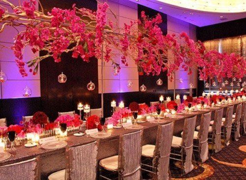 décoration de table suspendues fleurs roses et violettes sur rail le long des tables